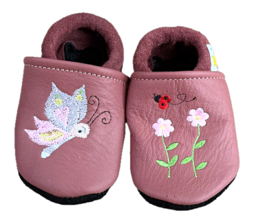 Lederpuschen Schmetterling und Blumen auf Terrakotta